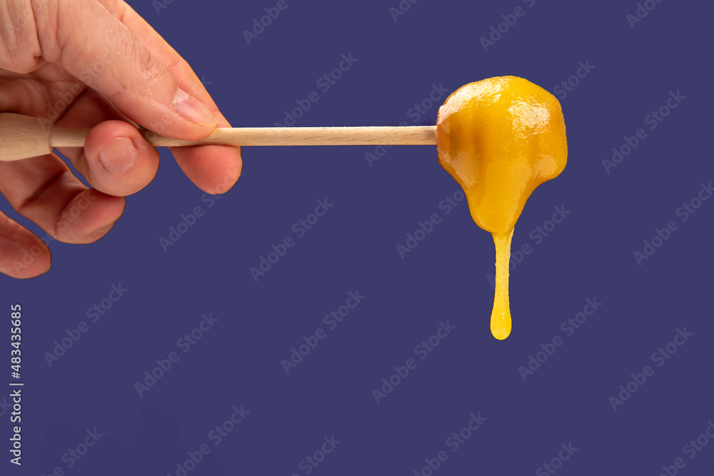 Fresh viscous flower honey falls down from a wooden spoon. vitamin organic food Fresh viscous flower honey falls down from a wooden spoon. vitamin organic food