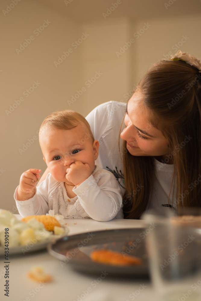 Watching her baby eat while she smiles