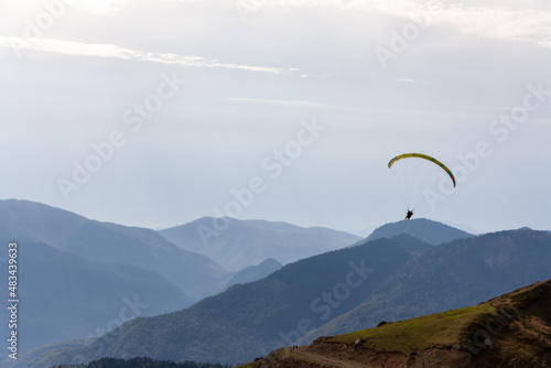 A man with a paraglider on a background of mountains