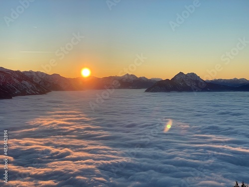 Sonnenuntergang über dem Nebel der Stadt Salzburg mit dem Untersberg
