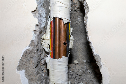 Damaged copper pipe in a wall