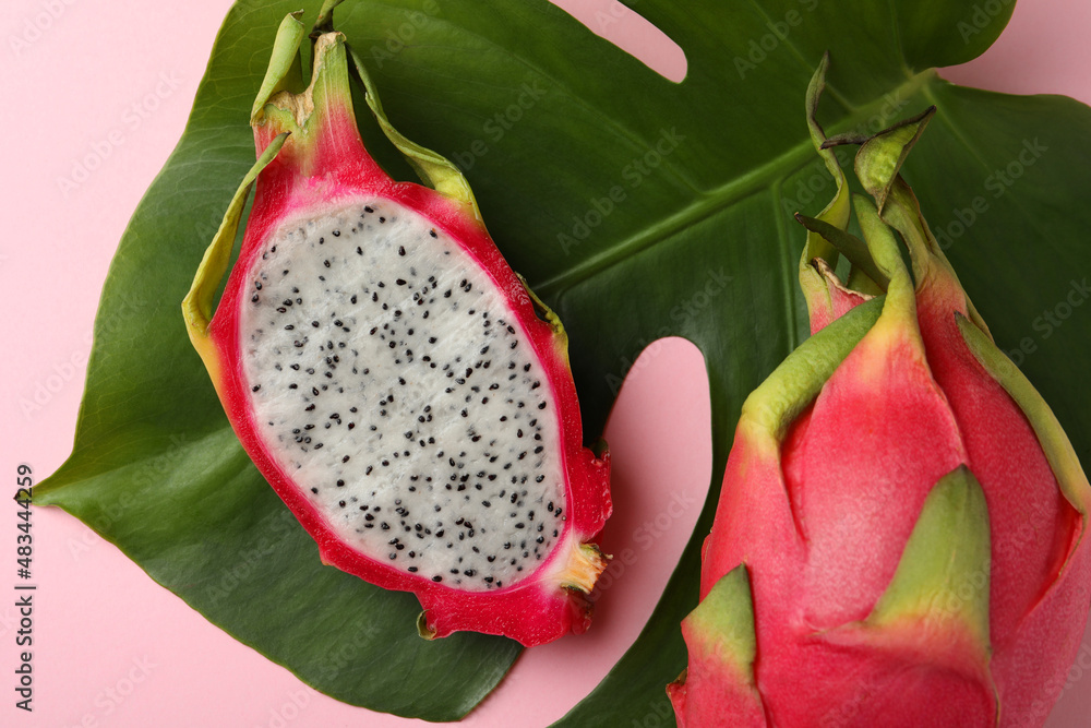 Delicious cut and whole white pitahaya fruits with green leaf on light pink background, flat lay Delicious cut and whole white pitahaya fruits with green leaf on light pink background, flat lay