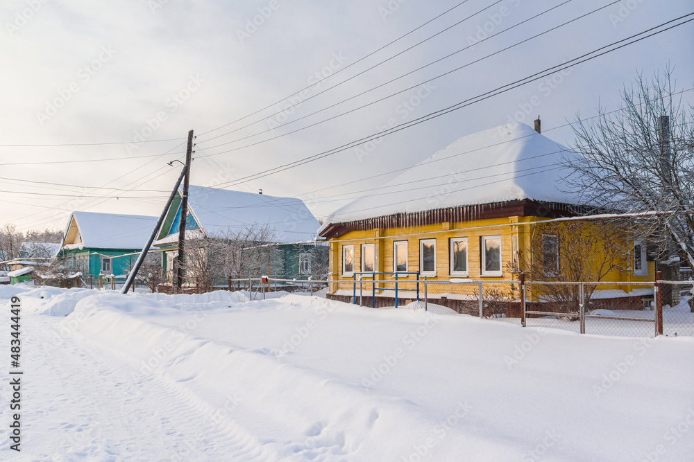 Street with old wooden houses in the village in winter