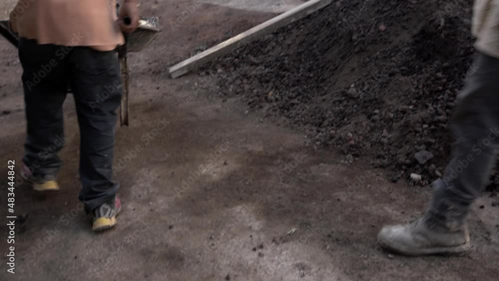Worker carrying cement on a wheelbarrow Worker carrying cement on a wheelbarrow
