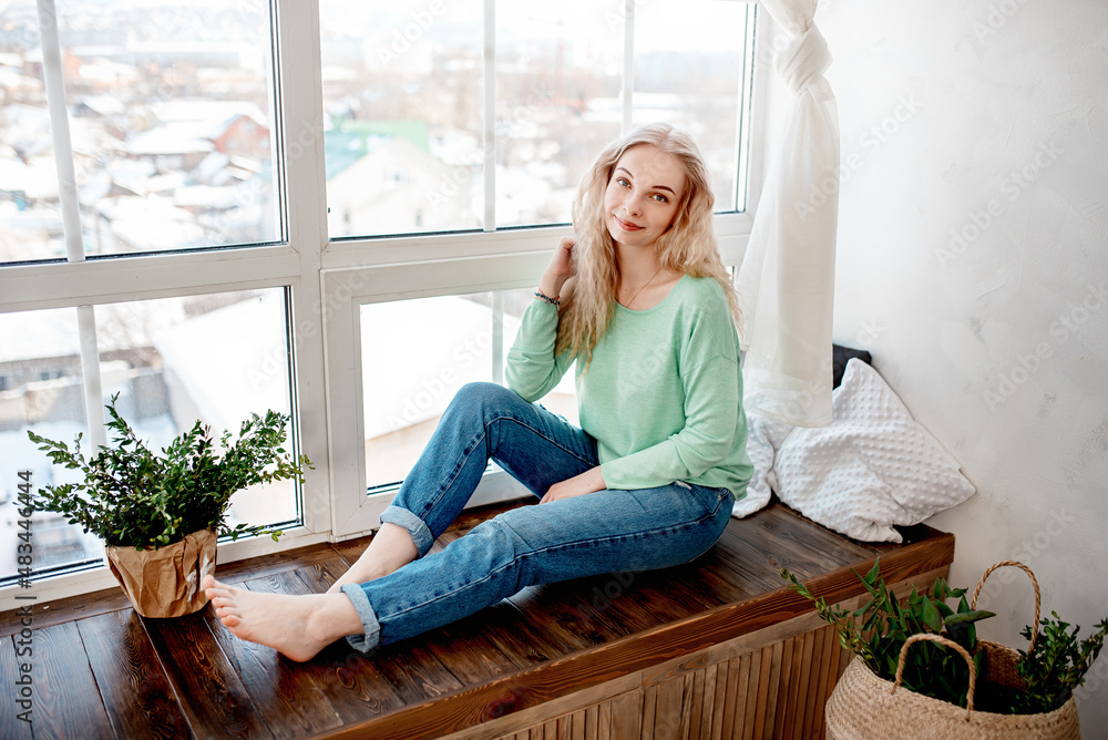 Young blond woman at home in a comfortable environment of scandinavian interior Young blond woman at home in a comfortable environment of scandinavian interior
