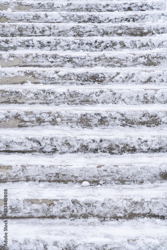 Close-up of a gray concrete staircase outdoors. Remains of white snow are visible on the steps. Background. Texture.