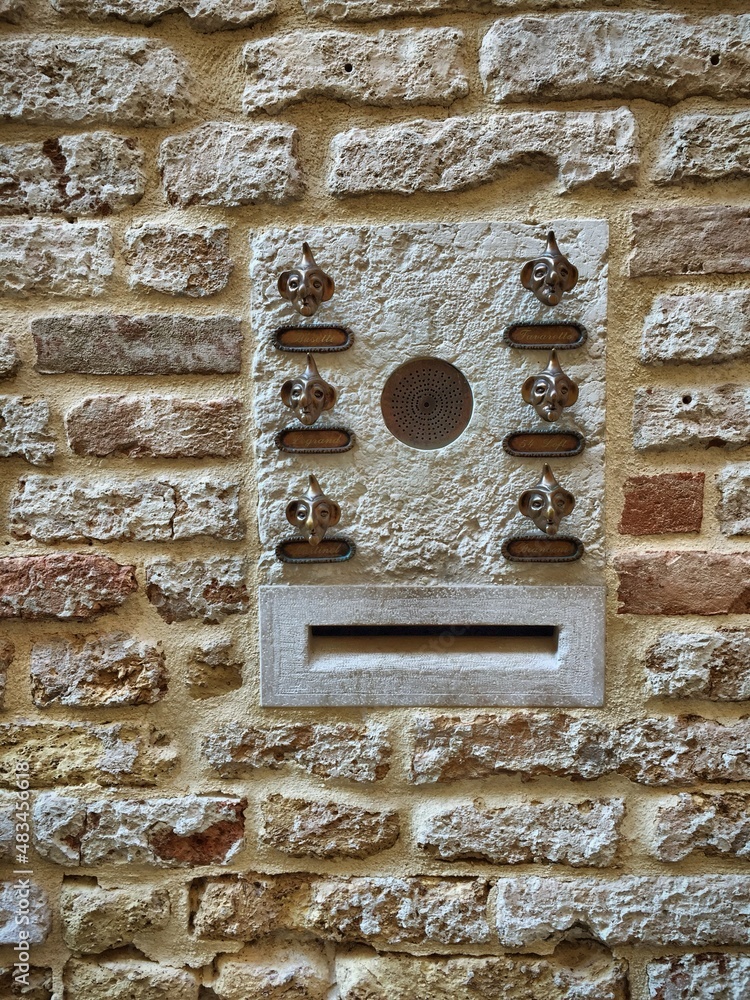 Briefkasten und Klingeln aus Bronze-Köpfen in einer Mauer in Venedig, Italien Briefkasten und Klingeln aus Bronze-Köpfen in einer Mauer in Venedig, Italien