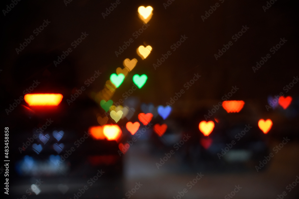 Night city lightis and car headlights in the shape of hearts. Bokeh. Valentine's Day, Love, romance concept. Background.