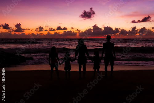 Family at sunset near the ocean .Contours of people.