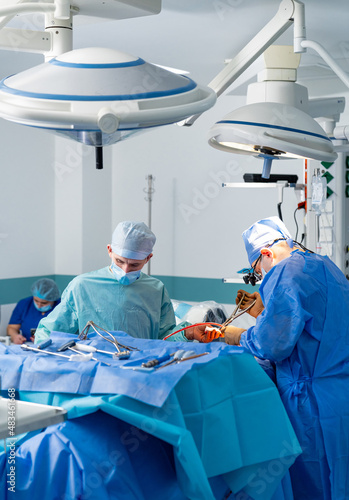 Medical team performing surgical operation in modern operating room © Vadim