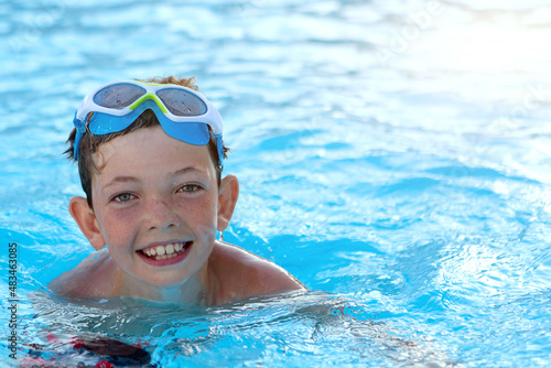 child in swimming pool. handsome boy 10 years old smiling in the pool. boy swimming goggles © екатерина Цыганок