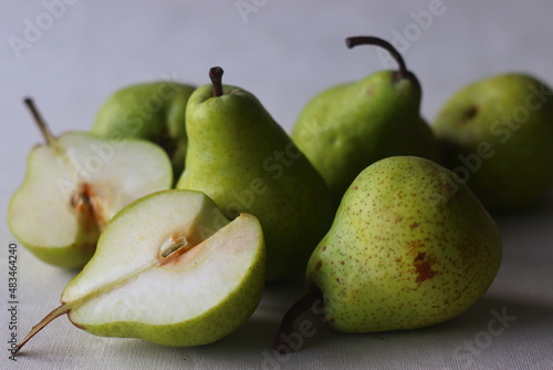 Juicy flavourful green colour pears along with cut slices randomly placed