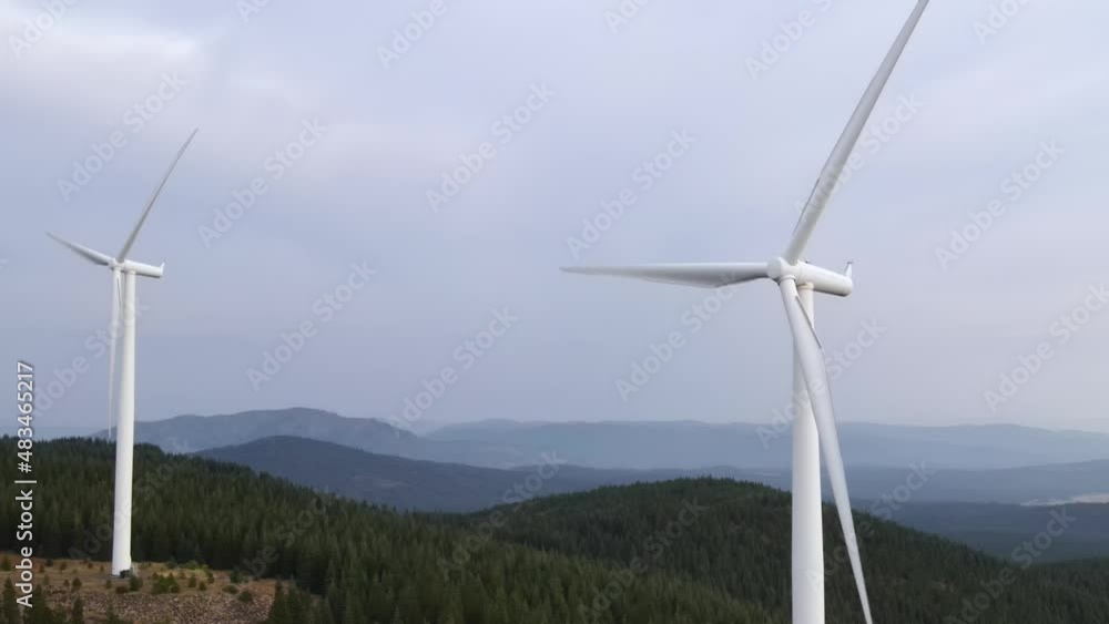 Aerial shot of a row of wind turbines along the ridge of a mountain Aerial shot of a row of wind turbines along the ridge of a mountain