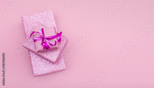 Several gift boxes lie on top of each other on a pink background with copy space. © Татьяна Качайло