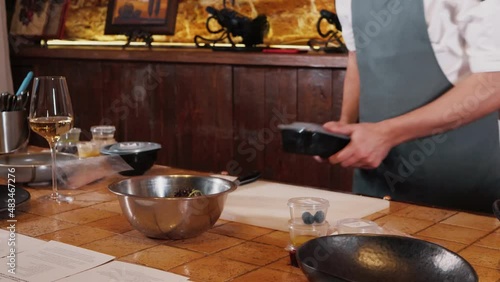 The chef on the stream prepares a dish of fried fish with broccoli and sauce