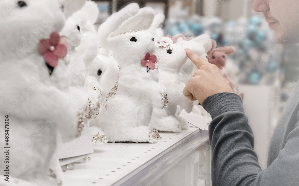 Young man points to the Easter Bunny's nose with his finger. Selective soft focus Young man points to the Easter Bunny's nose with his finger. Selective soft focus