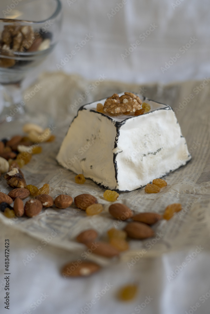 Various types of cheese with white mold on packaging paper. Home production, natural products.