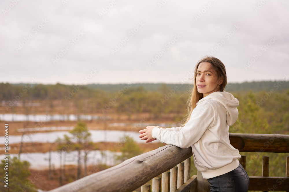 Lifestyle photo A girl trench coat in nature.  viru bog trail in Estonia. Travel,  exploration, healthy lifestyle, active rest