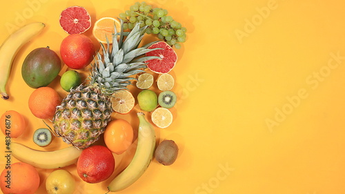 Fototapeta Naklejka Na Ścianę i Meble -  Detox diet and weight loss concept. summer tropical fruits and vegetables on a yellow table, top view, healthy and natural food, source of vitamin C, store banner, selective focus, space for text
