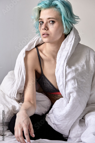 Upset sad caucasian woman sitting on bed alone, feeling lonely, unhappy female has psychological troubles, trauma, thinking about problem in bedroom, unwanted pregnancy. portrait. at home