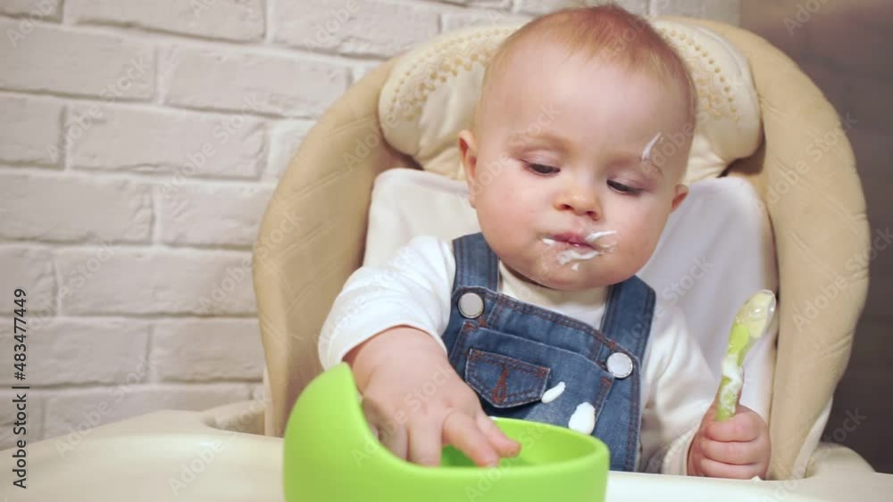 baby licks her mouth with her tongue then dips her fingers into cup of food baby licks her mouth with her tongue then dips her fingers into cup of food