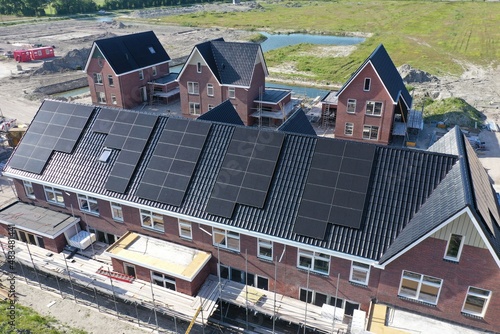 Newly built well-insulated houses with black solar panels and heat pumps for economical energy consumption, this is the future for many homes. Drone view