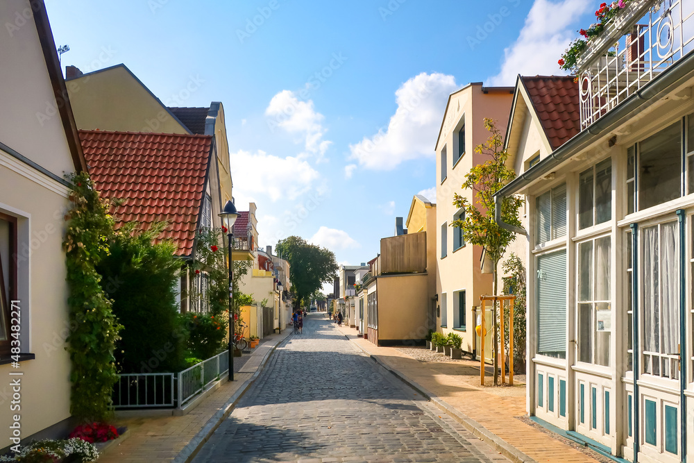 A colorful, narrow street of homes and shops in the Baltic coastal resort village of Warnemunde Rostock, Germany.