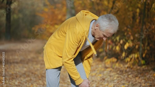 Aged man feeling pain in the knee while jogging in park, meniscus inflammation