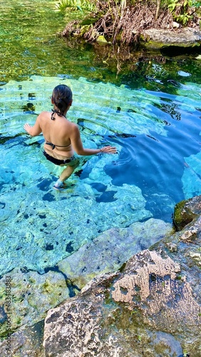 Woman entering cenote waters, Mexico.