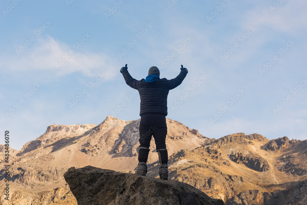 tourist standing on top of a rocky mountain