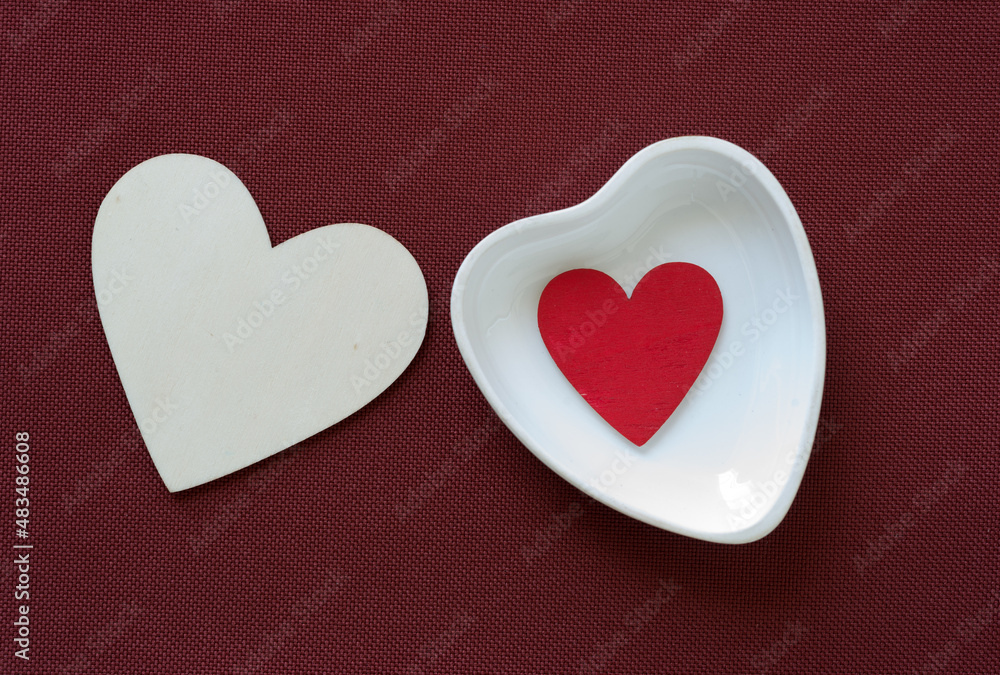 heart shaped dish with wooden hearts on red brown fabric heart shaped dish with wooden hearts on red brown fabric