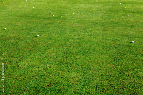 A golf course with balls scattered all over the course.