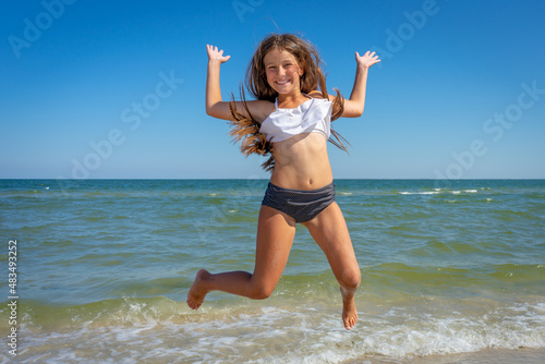 Wallpaper Mural Flying jump beach little happy girl on blue sea shore in summer vacation Torontodigital.ca