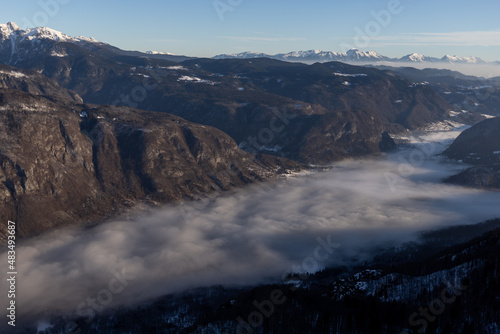 mountain peaks covered with snow and foggy valley