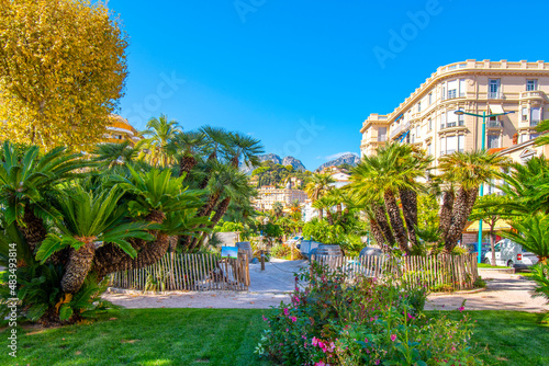 The Alpes Maritimes mountains rise behind the Jardins Bioves in the city center of the seaside resort city of Menton, France, on the French Riviera.	 photo