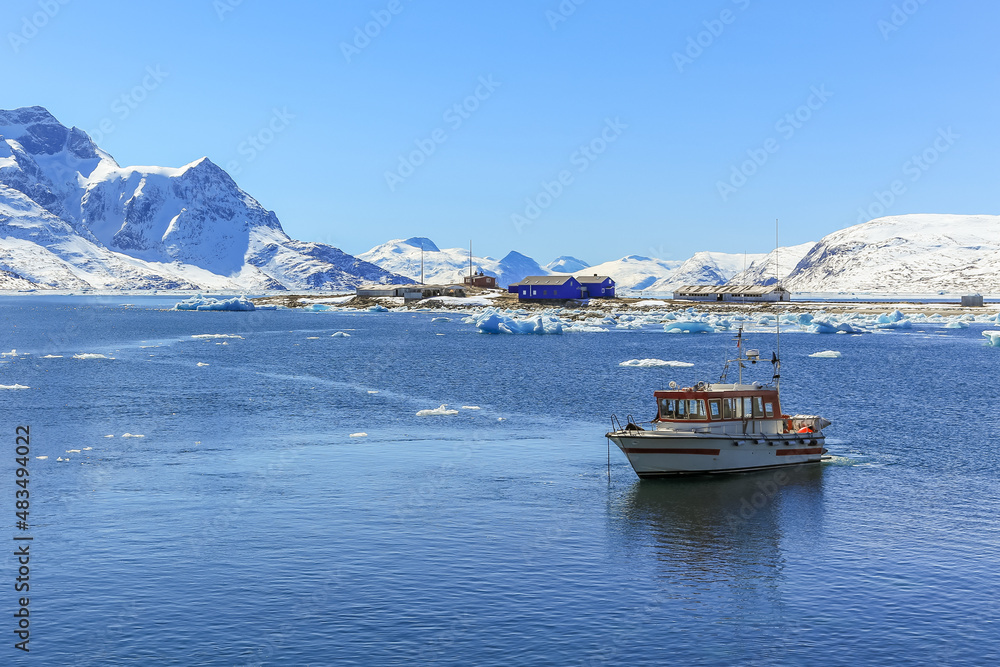 Boat anchored in the lagoon and Qoornoq former fishermen village in the middle of Nuuk fjord, Greenland Boat anchored in the lagoon and Qoornoq former fishermen village in the middle of Nuuk fjord, Greenland