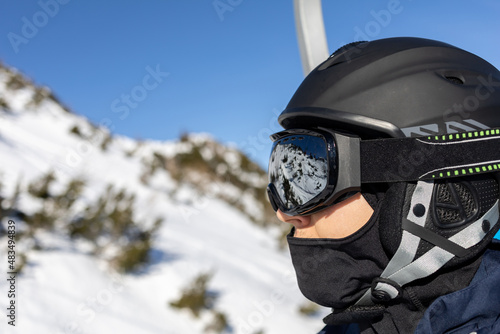 ski resort man on chairlift in helmet and mask