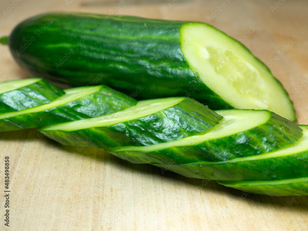 A smooth, medium-sized cucumber cut into slices. Cucumber on a cutting board. Vegetable isolate. Fresh ripe vegetable A smooth, medium-sized cucumber cut into slices. Cucumber on a cutting board. Vegetable isolate. Fresh ripe vegetable