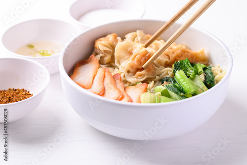 Noodles soup with wonton dumpling and grilled red pork in bowl on white background, Asian food photo