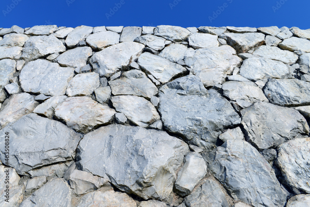 Fototapeta premium Stone wall with blue sky