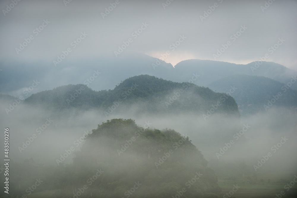 Aerial View across the Vinales Valley in Cuba. Morning twilight and fog. Fog at dawn in the Valley of Vinales in Pinar del Rio, famous for tobacco plantations in Cuba, world heritage site of Unesco Aerial View across the Vinales Valley in Cuba. Morning twilight and fog. Fog at dawn in the Valley of Vinales in Pinar del Rio, famous for tobacco plantations in Cuba, world heritage site of Unesco