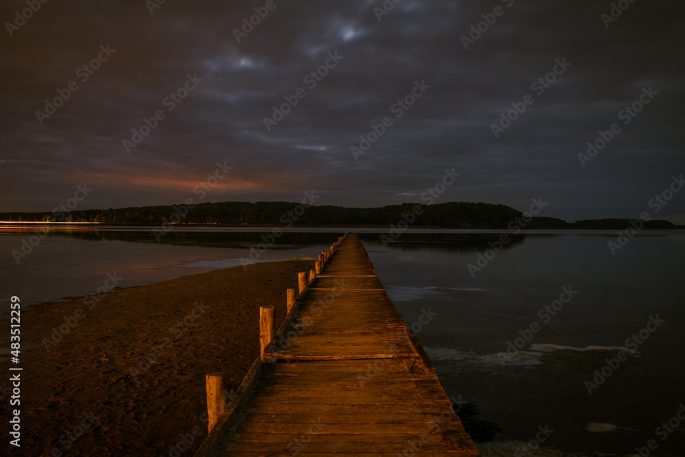 Naklejka premium The Jasmunder Bodden coast after dark, with the pier in Lietzow, Mecklenburg-Western Pomerania, Germany