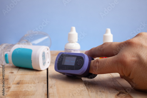 oxímetro de mão azul, aparelho portátil utilizado para medir e monitorar a oxigenação no sangue photo