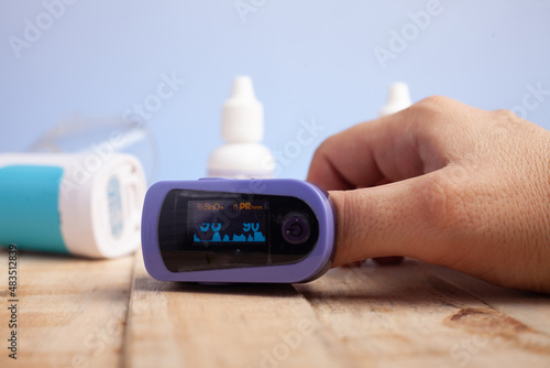 oxímetro de mão azul, aparelho portátil utilizado para medir e monitorar a oxigenação no sangue photo