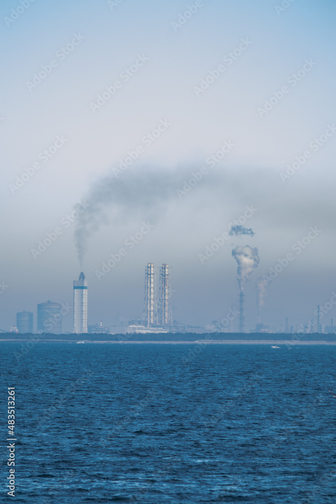 海岸線と煙が出る工場の風景