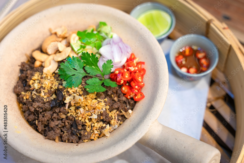 Chinese Black Olive Stir-fried Rice minced pork with cashew nut delicious Chinese food served in a white clay pot selective focus.