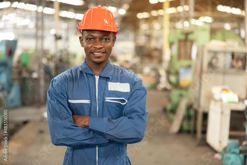 Foto Portrait of a black factory worker in a hardhat staring at the photo while standing in a workshop, copy space, and factory industrial engineering