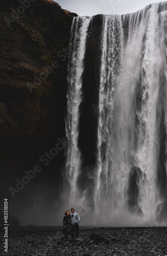 Couple Posing at the Bottom Giant Skogafoss Waterfall in Iceland