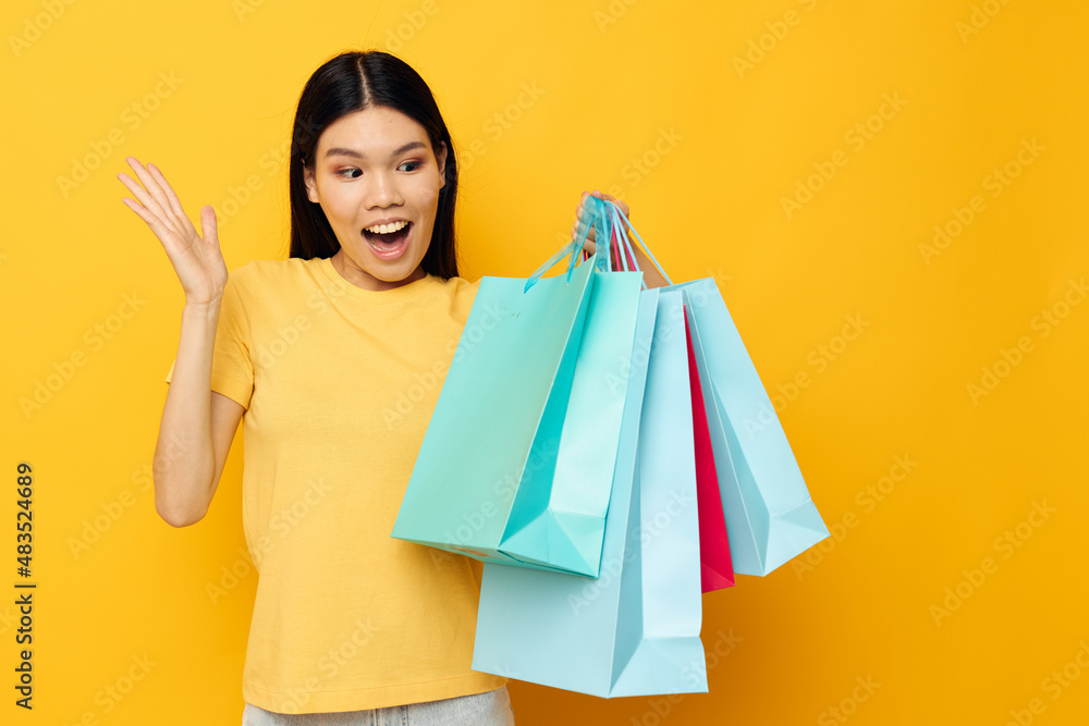 woman with Asian appearance with packages in hands shopping isolated background unaltered woman with Asian appearance with packages in hands shopping isolated background unaltered