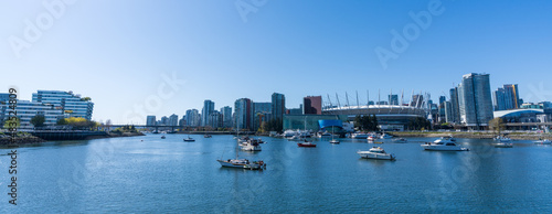 Vancouver, BC, Canada - April 16 2021 : Vancouver marina, False Creek, modern buildings skyline in the background. BC Place. photo